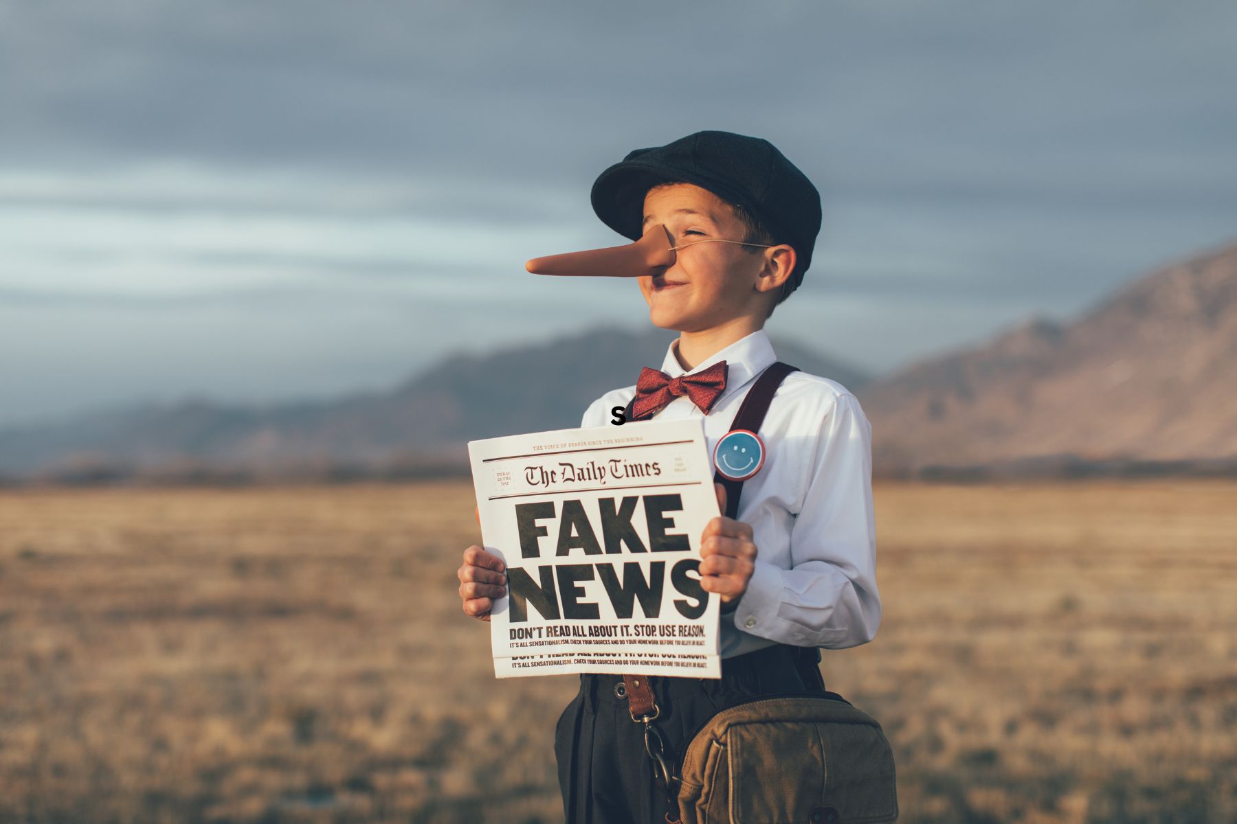 Picture of boy with a fake newspaper and a long nose